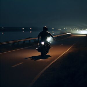 Motorcyclist riding along a river at night